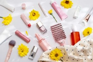 Cosmetics and yellow flowers on white background