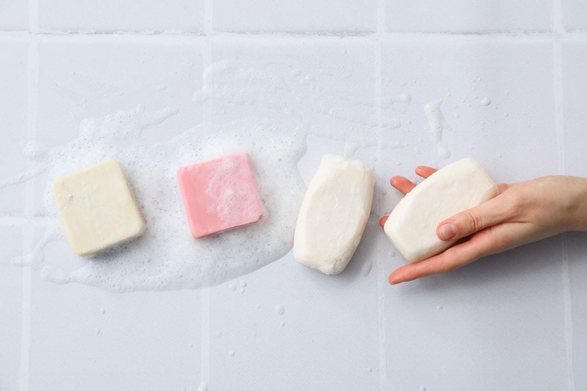 Hand holding soap bars with foam.