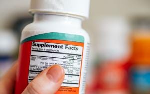 Hand holding supplement facts bottle label
