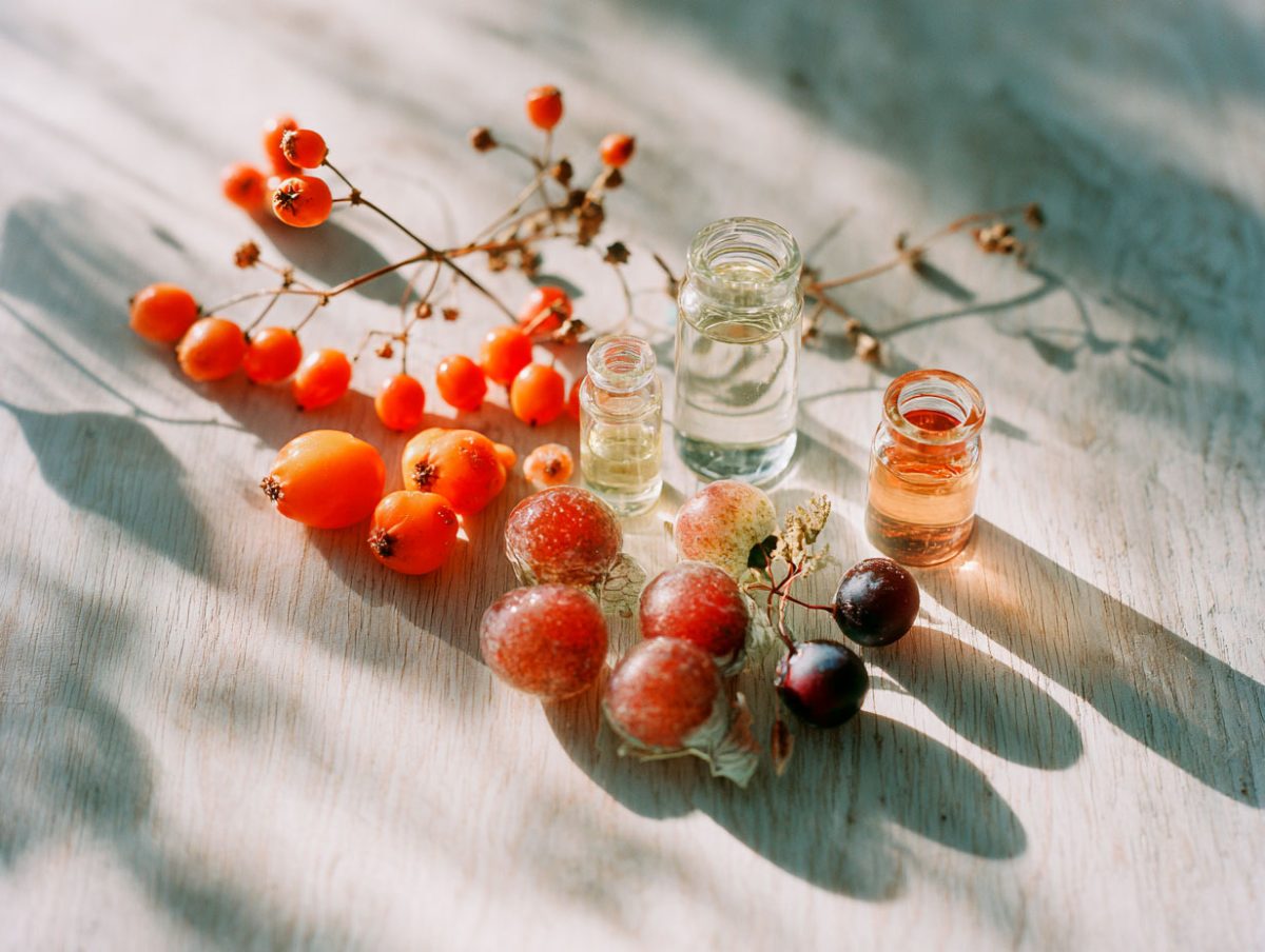Berries and essential oils on wooden table