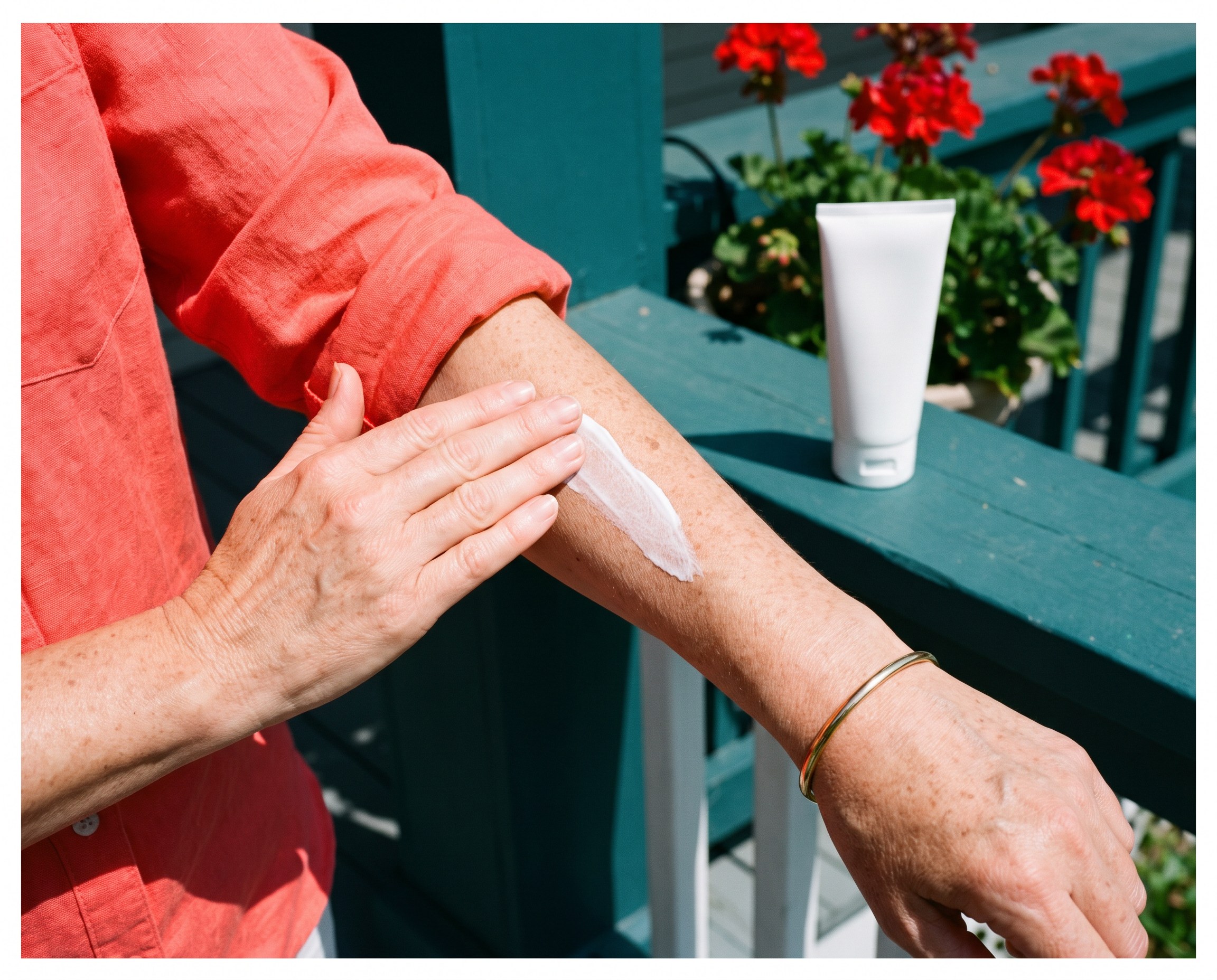 Close-up of a woman smoothing sunscreen onto her forearm on a sunny porch